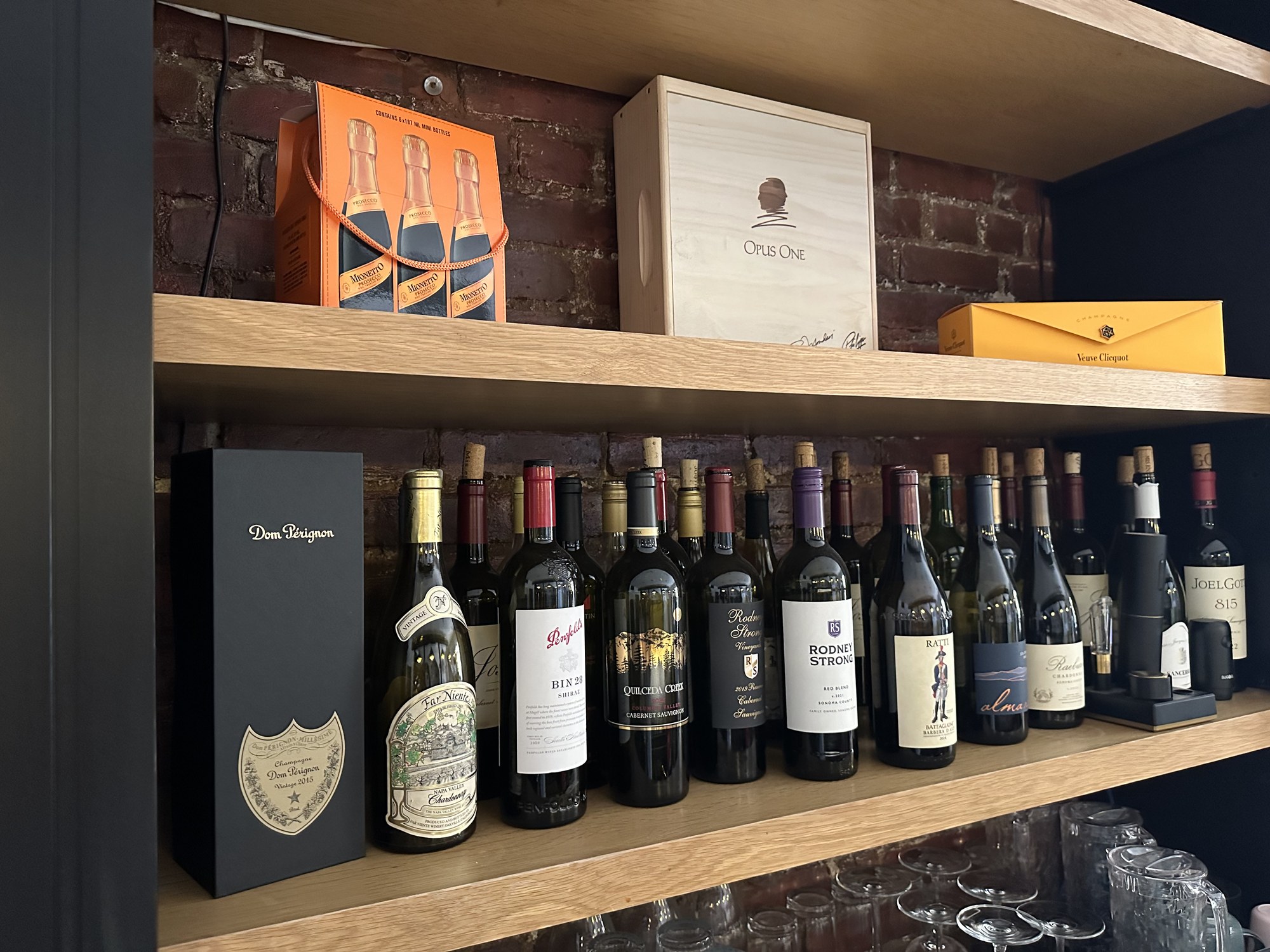 Wine bar at Spelling Thai Bistro with bottles and gift boxes on oak shelves